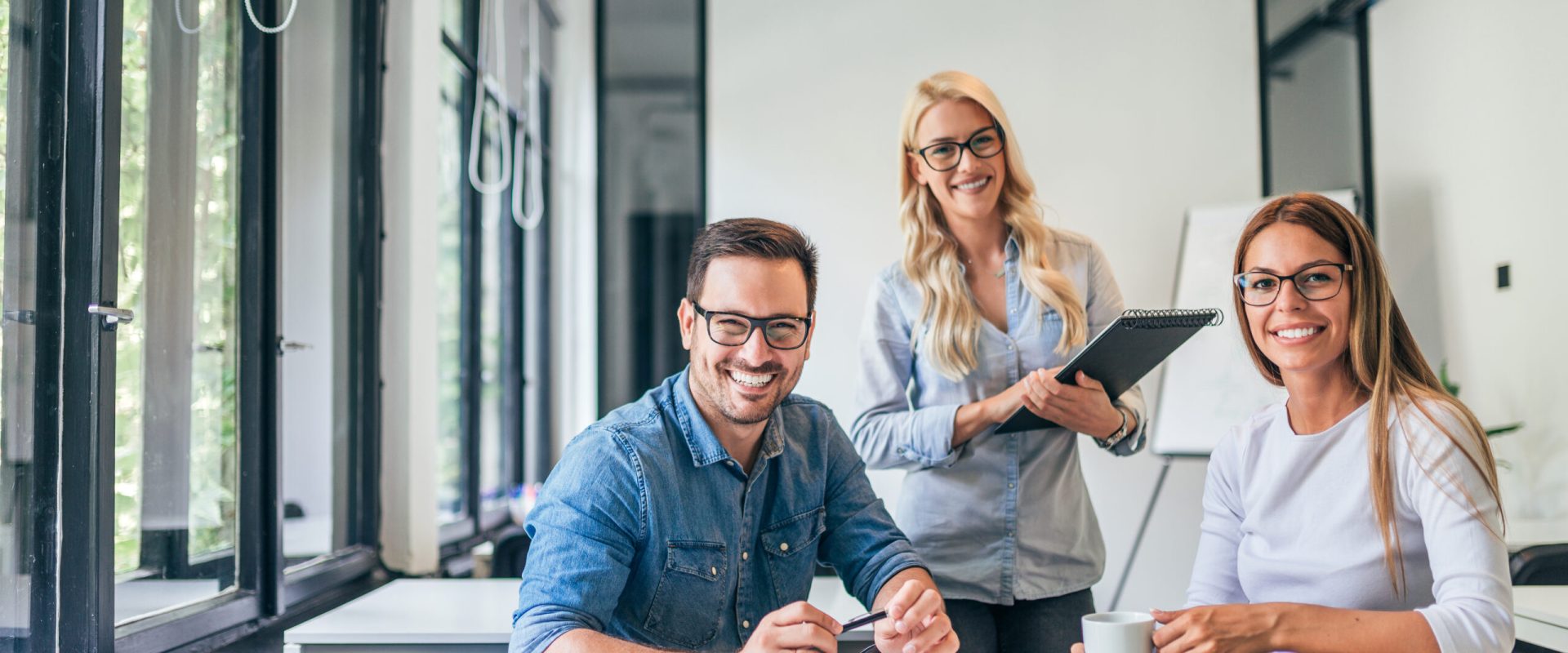 Beautiful casual business people in modern bright office. Looking at camera. Teamwork concept. Beautiful casual business people in modern bright office. Looking at camera. Teamwork concept.